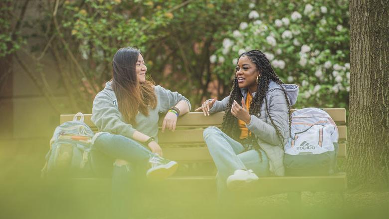 Two people talking on a bench